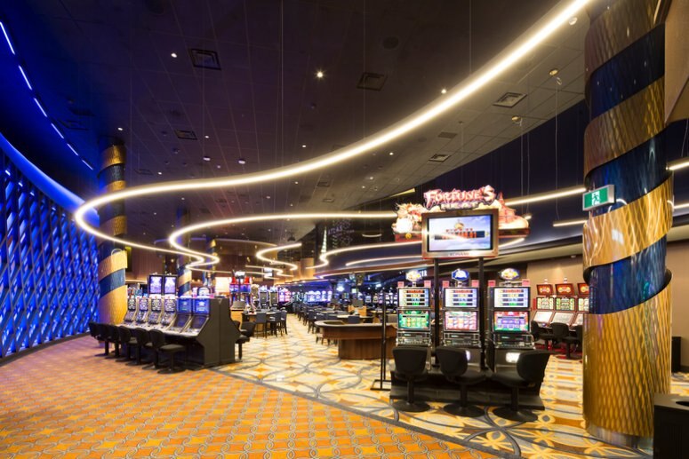 Lightnet's Liquid Line suspension lights illuminate the floor of Grand Villa Casino in a photo that emphasizes the light output of the fixtures. Photo by Jim Dobie Photography.